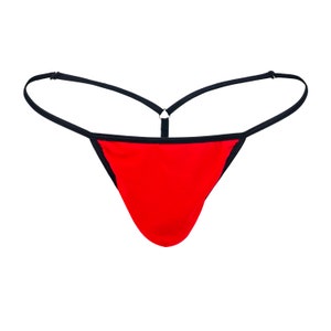 Puede incluir: Tanga roja con ribete negro y tirantes ajustables.