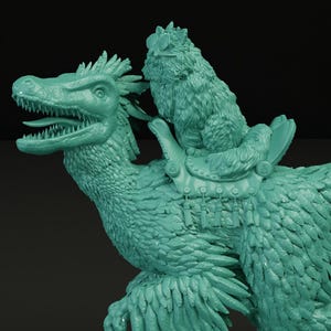 May include: A teal-colored figurine of a feathered dinosaur with an open mouth, ridden by a smaller, furry creature. The dinosaur has a saddle and is standing on a base with grass and a brick pattern. The figurine is a fantasy-themed collectible.
