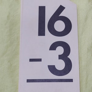 May include: A white card with the math problem "16 - 3" written in black. The card also includes the text "47643 • Copyright © 1992, 1980 A Beka Book Publications 139".