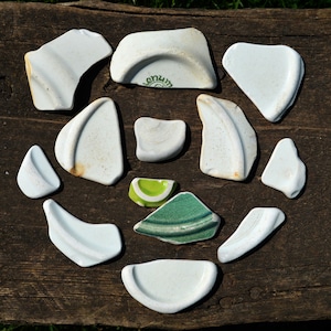 Puede incluir: Un juego de tres tazas de cerámica con un acabado mate moteado. Las tazas son de color crema, gris claro y gris oscuro. Cada taza tiene un diseño simple y minimalista y un asa redondeada.