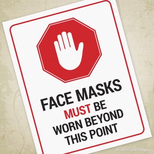 May include: A white sign with a red stop sign symbol and the text "FACE MASKS MUST BE WORN BEYOND THIS POINT".