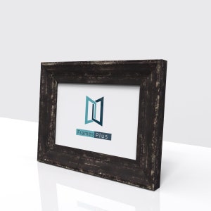 May include: A black wooden picture frame with a distressed finish. The frame has a white mount and a clear glass front. The frame is displaying a logo for Frames Plus.
