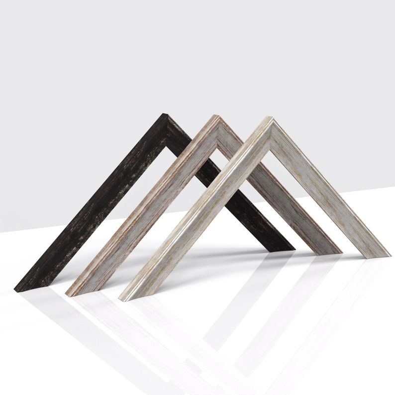 May include: Three picture frames in different wood finishes: black, whitewashed, and grey. The frames are arranged in a triangular shape.