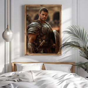 May include: A framed print featuring a muscular man in ancient Roman armor, including a breastplate, shoulder guards, and a shield. The artwork is set against a blurred background, with a wooden frame. The image is displayed above a bed with white linens.