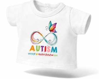May include: White t-shirt with a colourful infinity symbol, a butterfly, and the word "AUTISM" in rainbow hues. The text "accept understand love" is below the word autism. The t-shirt is designed for children.