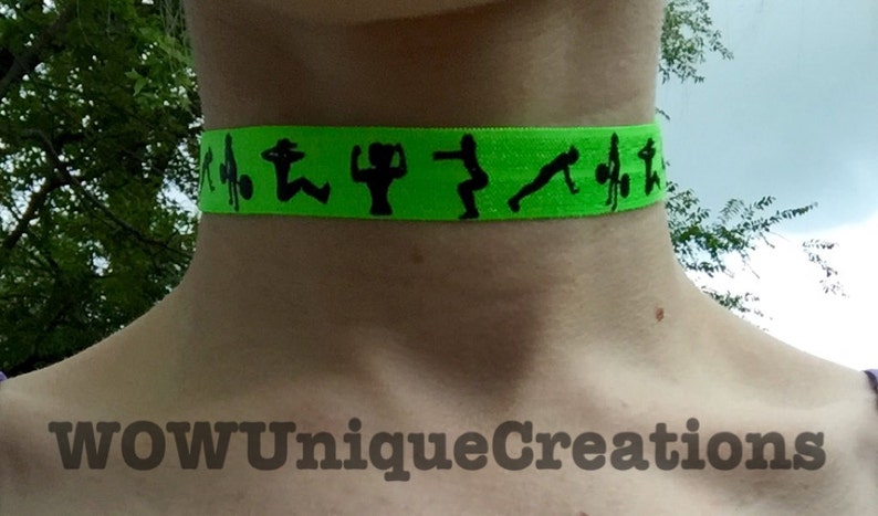 Puede incluir: Un collar gargantilla de color verde ne&oacute;n con siluetas negras de personas haciendo ejercicio. El collar tiene el texto "WOW Unique Creations" en la parte inferior.