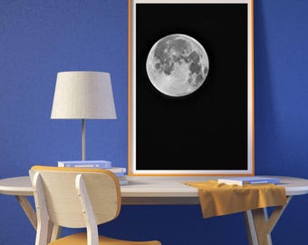 May include: A black and white photograph of a full moon against a dark sky. The moon is the main focus of the image and is framed by a wooden frame.