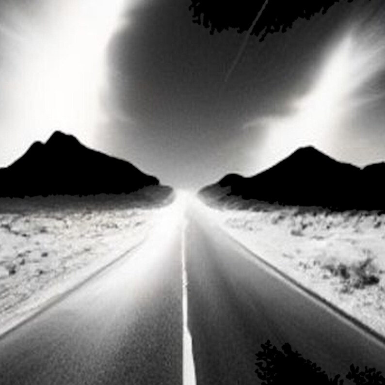 Op de afbeelding: Een zwart-witfoto met hoog contrast van een rechte asfaltweg die naar een heldere horizon leidt. De sc&egrave;ne wordt geflankeerd door donkere, silhouetachtige bergketens aan beide kanten, met een dramatische, bewolkte lucht erboven.