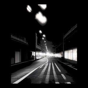 Pode incluir: Uma fotografia a preto e branco de alto contraste de uma rua deserta &agrave; noite. A cena apresenta uma longa estrada com marca&ccedil;&otilde;es de faixa, ladeada por edif&iacute;cios escuros com montras iluminadas e candeeiros de rua suspensos.