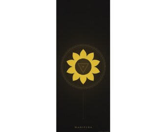 Op de afbeelding: Een rechthoekige zwarte yogamat met een centraal geplaatste gele lotusbloemafbeelding met tien bloemblaadjes en een driehoek erin. De tekst MANIPURA staat onder de afbeelding en een klein vierkant logo met BLK MAT staat onderaan.