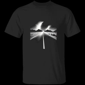 Op de afbeelding: Een zwart T-shirt met korte mouwen en een centrale grafische print van een woestijnweg die naar een verre bergketen leidt onder een heldere, gloeiende lucht. De afbeelding maakt gebruik van een contrastrijke zwart-witstijl.