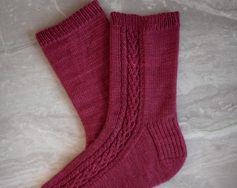 May include: A pair of burgundy knitted socks with a cable knit pattern.