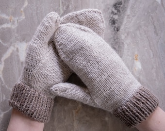 May include: A pair of knitted mittens with a light brown and beige color scheme. The mittens have a textured knit pattern and a brown cuff.
