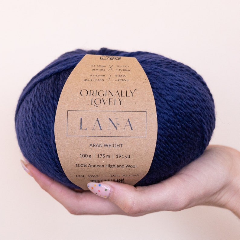 May include: A ball of dark blue yarn labeled "Originally Lovely Lana" with the text "Aran Weight 100g | 175m | 191 yd 100% Andean Highland Wool COL 6269 LOT 707143".