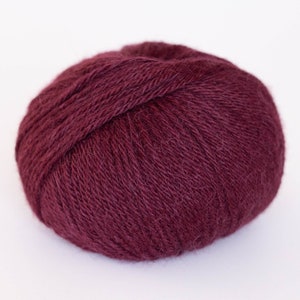 May include: A ball of deep burgundy yarn, perfect for knitting or crocheting.