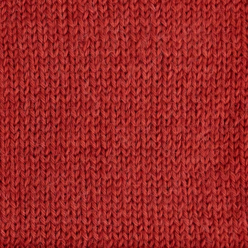 May include: Close-up of a red knitted fabric with a textured pattern.