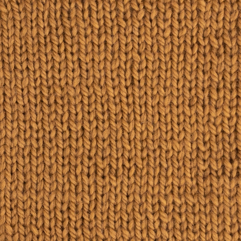 May include: Close-up of a brown knitted fabric with a textured pattern. The fabric is made of soft, fuzzy yarn.