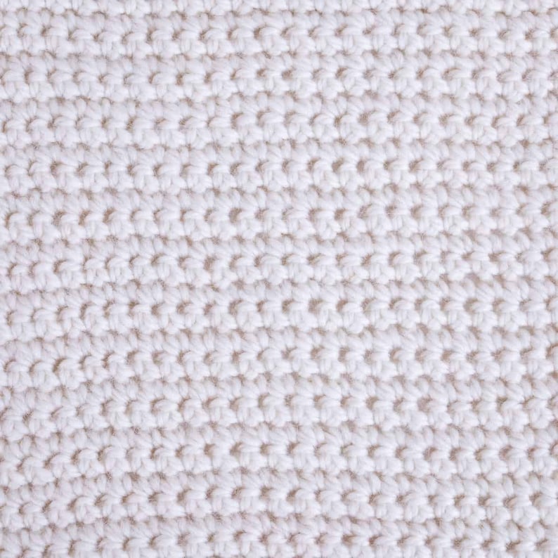 May include: Close-up of a white knitted fabric with a textured pattern.