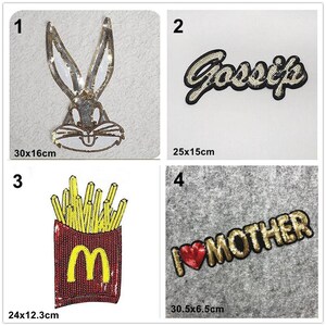 Könnte beinhalten: Vier Bügelbilder mit verschiedenen Designs. Das erste Bügelbild ist ein Cartoon-Kaninchen mit goldenen Pailletten, das 30x16 cm misst. Das zweite Bügelbild ist aus goldenen Pailletten mit dem Wort "Gossip" in Schwarz, das 25x15 cm misst. Das dritte Bügelbild ist ein rotes und gelbes Pommes-Design mit dem Buchstaben "M" in der Mitte, das 24x12,3 cm misst. Das vierte Bügelbild ist aus goldenen Pailletten mit den Worten "I love Mother" in Schwarz mit einem roten Herzen, das 30,5x6,5 cm misst.