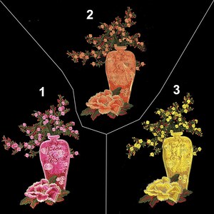 May include: Three embroidered floral arrangements in vases. The first arrangement is pink with a pink vase, the second is orange with an orange vase, and the third is yellow with a yellow vase.