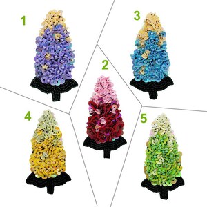 May include: Five different colored sequined flower-shaped appliques. The appliques are in shades of purple, pink, blue, yellow, and green. Each applique is about 3 inches tall.