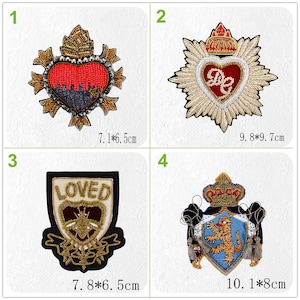 May include: Four embroidered iron-on patches with different designs. The first patch is a red heart with a crown and gold embellishments. The second patch is a gold star with a red heart in the center. The third patch is a black shield with the word "LOVED" in gold lettering. The fourth patch is a blue shield with a lion and a crown. The patches are approximately 7.1 x 6.5 cm, 9.8 x 9.7 cm, 7.8 x 6.5 cm, and 10.1 x 8 cm.