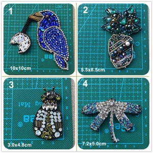 Puede incluir: Cuatro parches bordados para planchar con diferentes diseños: un pájaro azul con una flor blanca, una piña verde, una abeja negra y verde y una libélula azul. Los parches están sobre un fondo de cuadrícula verde con medidas en centímetros.