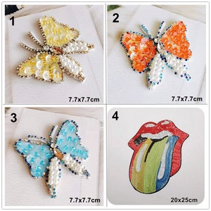 May include: Four iron-on patches, two butterfly designs in yellow, orange, blue, and white, and one red tongue design with rainbow sequins. The butterfly patches are 7.7 cm by 7.7 cm, and the tongue patch is 20 cm by 25 cm.