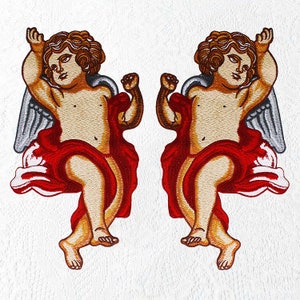 Könnte beinhalten: Zwei gestickte Patches von Cherubim mit Flügeln, jeder trägt eine rote Robe und hält eine Hand hoch. Die Cherubim haben hellbraunes Haar und sind in entgegengesetzte Richtungen gerichtet.