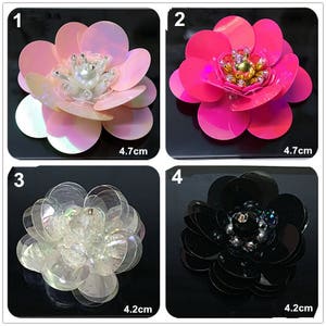Puede incluir: Cuatro adornos en forma de flor con lentejuelas y cuentas. Las flores son rosa, blanca, negra y rosa fuerte. Cada flor mide 4,7 cm o 4,2 cm de diámetro.