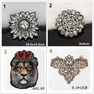 May include: Four decorative patches: 1) a 10.5x10.5 inch starburst crystal patch, 2) a 5x5 inch round crystal patch, 3) a 43x31.5 inch lion head patch with a red crown, and 4) a 9.5x12 inch ornate gold-tone patch with white pearls and crystals.