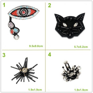 May include: Four decorative patches with beaded and rhinestone embellishments. The patches include an eye design (9.5 x 9.0 cm), a cat face (5.7 x 5.2 cm), and two abstract designs (1.9 x 1.9 cm).