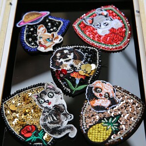 以下が含まれることがあります： 猫、パンダ、犬など、さまざまな動物をモチーフにした刺繍アイロン接着パッチ6個セット。パッチは、スパンコールとラインストーンで飾られています。