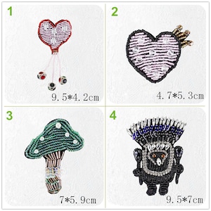 May include: Four beaded iron-on patches. The first patch is a pink heart with a crown and a beaded string of pearls. The second patch is a green mushroom with a brown stem. The third patch is a black owl with blue and white accents. The fourth patch is a pink heart with a beaded string of pearls.