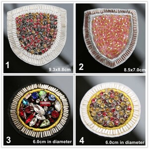 May include: Four embroidered patches with various colored rhinestones. The patches are in the shapes of a shield and a circle. The shield patches are 9.3 x 8.8 cm and 8.5 x 7.0 cm. The circle patches are 6.0 inches in diameter.