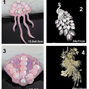 Könnte beinhalten: Vier verschiedene Bügelbilder mit einer rosa Qualle, einem silbernen Pfau, einer rosa Muschel und einem goldenen Pfau. Die Patches sind alle mit Pailletten und Perlen verziert. Die Maße jedes Patches sind unter jedem Bild angegeben.