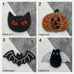 May include: Four Halloween-themed beaded brooches are displayed. They include a black cat (5.0 x 4.6 cm), an orange pumpkin (7.0 x 6.2 cm), a black bat (9.5 x 5.0 cm), and a black bat with crystal wings (9.0 x 5.8 cm).