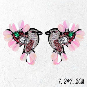 May include: Two pink and white bird-shaped appliques with sequins, beads, and rhinestones. Each applique measures 7 inches by 7 inches.