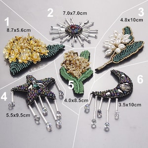 Puede incluir: Seis parches bordados diferentes con varios diseños, incluyendo una flor, una estrella, una luna creciente y un sol. Los parches están hechos con cuentas y lentejuelas y tienen una combinación de colores verde y negro. Los parches son de diferentes tamaños, que van desde 3,5 x 10 cm hasta 8,7 x 5,6 cm.
