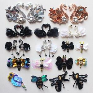 May include: Assortment of colorful embroidered iron-on patches featuring swans, butterflies, and bees. The patches are made of sequins, beads, and other embellishments.
