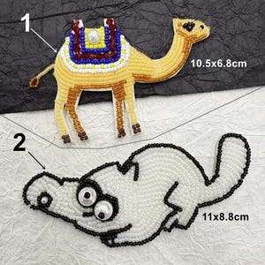 May include: Two beaded iron-on patches. The first patch is a camel with a saddle, 10.5 x 6.8 inches. The second patch is a white cartoon dog with black outlines, 11 x 8.8 inches.