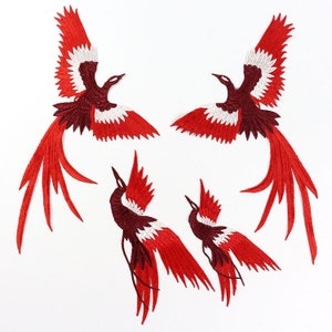 May include: Four red and white embroidered iron-on patches of a stylized phoenix bird with long tails.