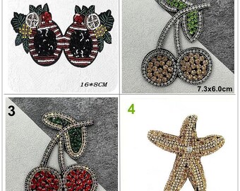 May include: Four iron-on patches with rhinestone embellishments. The patches are a red and black striped fruit, two brown cherries, two red cherries, and a gold starfish. The patches are 16x8cm, 7.3x6.0cm, 7.3x6.0cm, and 11.4x9.4cm.