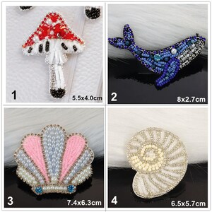 May include: A set of four beaded patches featuring a red and white mushroom, a blue whale, a pink and blue seashell, and a cream-coloured nautilus shell. Each patch includes dimensions: 5.5x4.0cm, 8x2.7cm, 7.4x6.3cm, and 6.5x5.7cm respectively.