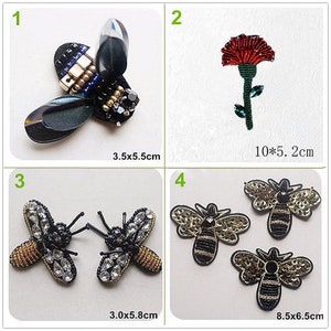 May include: A collection of beaded insect and floral embellishments. Includes a bee with iridescent wings, a red flower, two beaded butterflies, and three bee designs. Measurements are included.