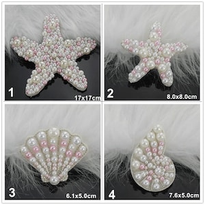 Puede incluir: Cuatro adornos de perlas y cuentas rosas en forma de estrella de mar y conchas. Las estrellas de mar miden 17x17cm y 8.0x8.0cm. Las conchas miden 6.1x5.0cm y 7.6x5.0cm.
