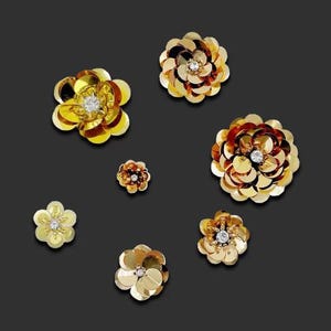 Peut inclure: Assortiment de décorations en forme de fleurs dorées avec des centres en strass transparents.