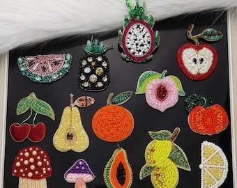 May include: Assortment of colorful beaded fruit and vegetable patches, including a pineapple, watermelon, peach, pear, papaya, lemon, and a dragon fruit. The patches are perfect for adding a touch of whimsy to clothing, bags, or other accessories.
