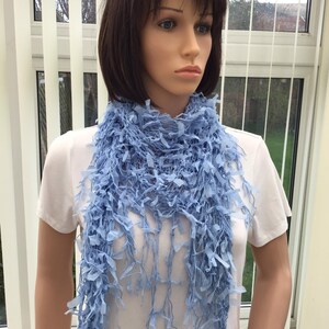 Peut inclure: Une &eacute;charpe bleu clair avec un design frang&eacute;. L'&eacute;charpe est faite d'un mat&eacute;riau doux et l&eacute;ger, parfait pour ajouter une touche de couleur &agrave; n'importe quelle tenue.