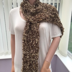 May include: A brown and beige fuzzy scarf with a textured knit.